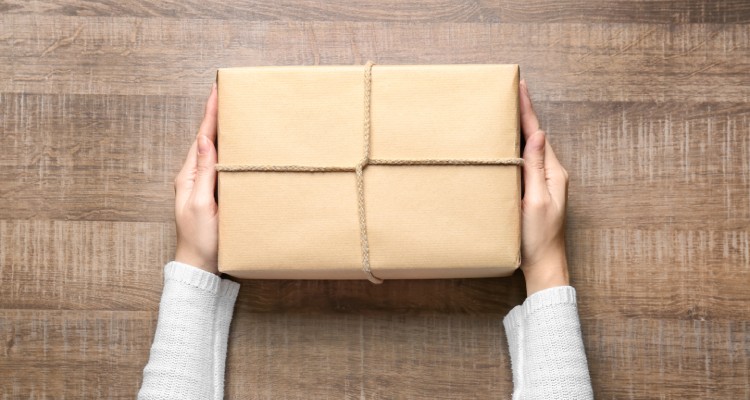 Woman with parcel box on wooden background